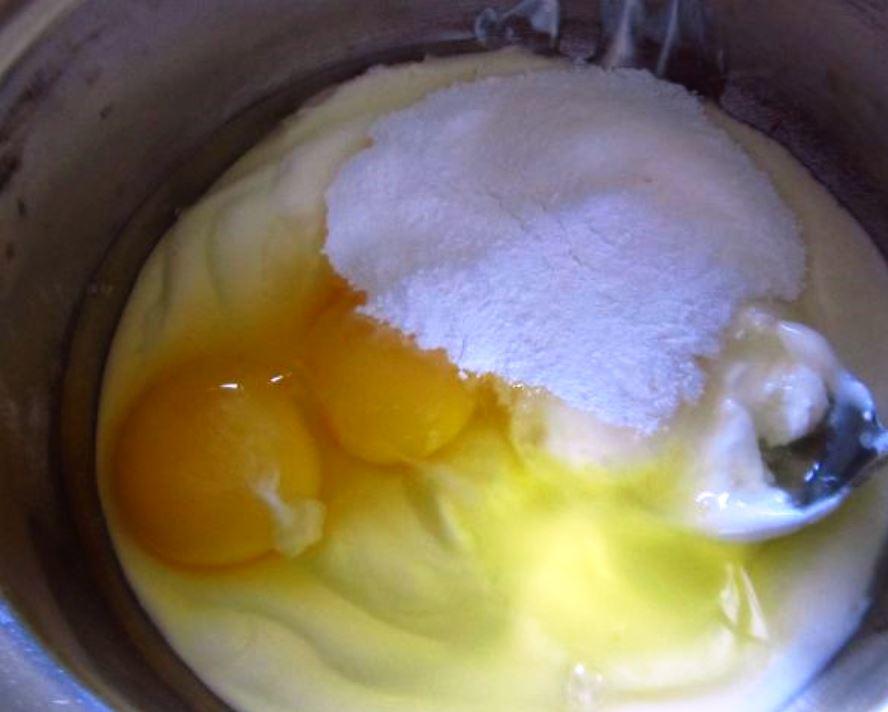 В заранее подготовленную емкость вливаем сметану, добавляем яйца и сахар по вкусу