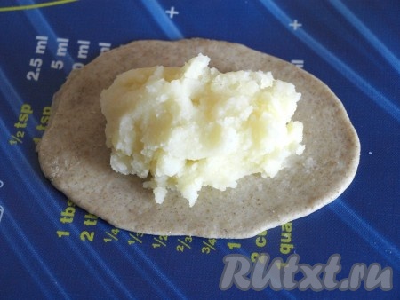 Каждый шарик раскатывать в лепёшку около 12-13 см в диаметре, можно и немного меньше, в зависимости от того, какой размер вам хочется получить в итоге. Для начинки приготовить картофельное пюре: сварить картофель, размять его прессом и по вкусу добавить масло, соль, яйцо и молоко. Пюре должно быть мягким, но держать форму. По центру лепёшки выкладывать остывшее картофельное пюре.
