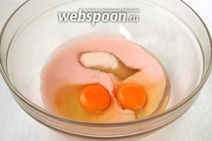 В миску вылить йогурт, добавить яйца и сахар.