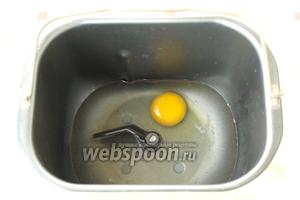 В ведро хлебопечки влить тёплую воду и добавить 1 яйцо.