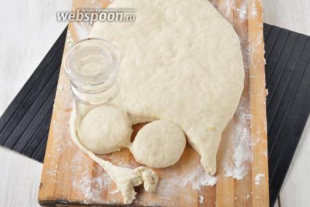Раскатать тесто на слегка присыпанной мукой доске. Толщина теста 2-2,5 сантиметра. С помощью стакана вырезать пончики.