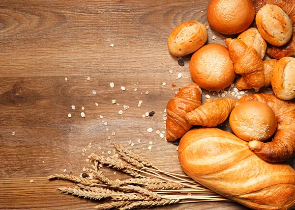 Ассортимент хлеб на деревянный стол — стоковое фото