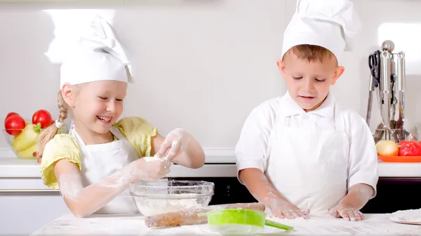 Счастливый маленький мальчик и девочка, приготовление пищи на кухне Лицензионные Стоковые Фото