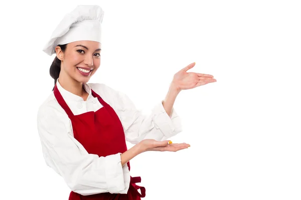 Женский шеф-повар, представляя что-то Лицензионные Стоковые Фото