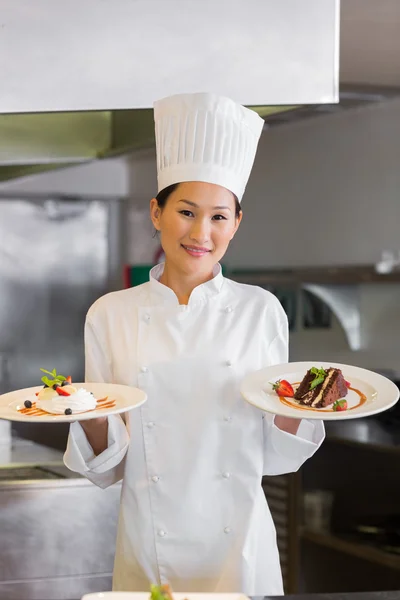 Уверены Женский шеф-повар Холдинг приготовленной пищи в кухне Лицензионные Стоковые Изображения