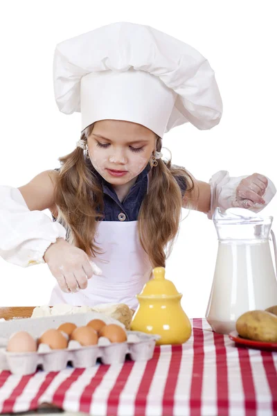 Маленький повар девушка в белый фартук перерывы яйца в глубокое блюдо Лицензионные Стоковые Фото