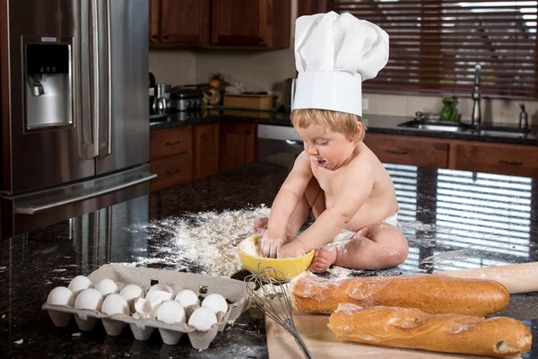 Детские Бейкер, сидя на кухне столешницу Стоковое Фото