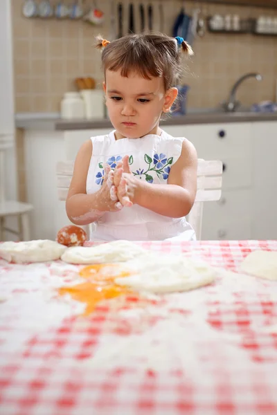 Счастливый маленький шеф-повар, играя с мукой, растяжения тесто Лицензионные Стоковые Фото
