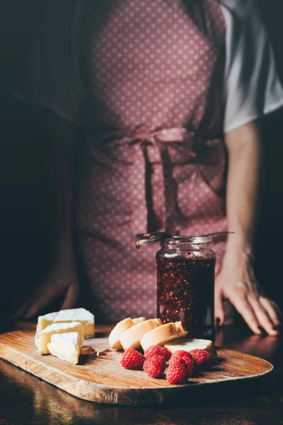 Cropped Image Woman Apron Standing Table Brie Baguette Slices Raspberries Лицензионные Стоковые Фото