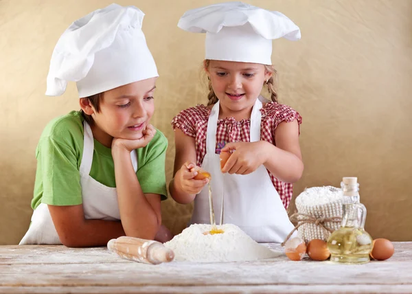 Дети, подготовка торт - начиная с мукой и яйцами Стоковое Фото