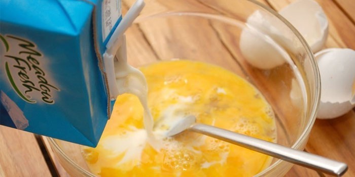 В миску со взбитыми яйцами добавляют молоко