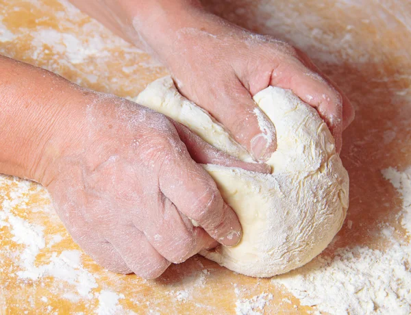Руки пожилой женщины месят тесто Стоковое Изображение