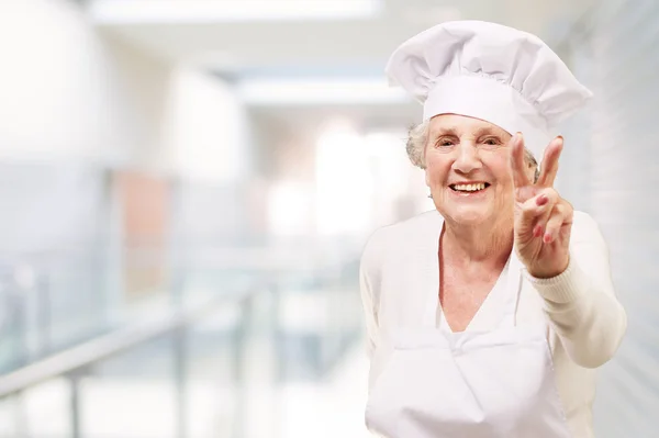Портрет готовить старшие женщины делают хороший жест в ресторане Стоковая Картинка
